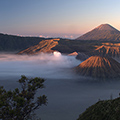 indonésie: Den se pomalu probouzí a vrcholky vulkánů zachytávají první paprsky světla.
